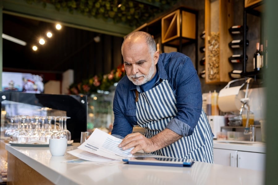 Owner reviewing paperwork for his business. Owner reviewing paperwork for his business.